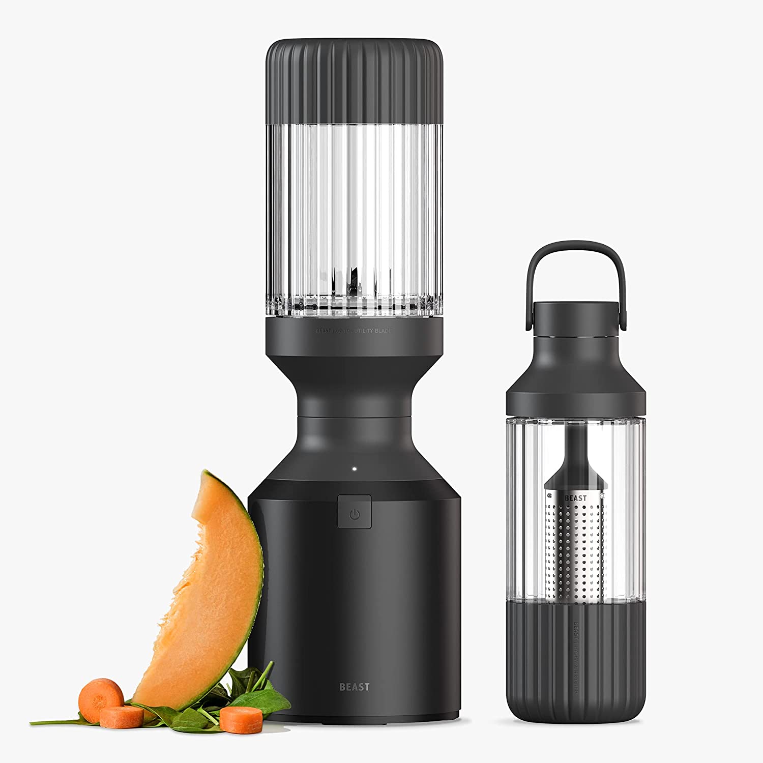 A sleek, black blender with transparent containers stands next to a matching water bottle with an infuser—one of the best fitness gifts. In front of the blender, there is a slice of cantaloupe melon, a piece of carrot, and a few spinach leaves.