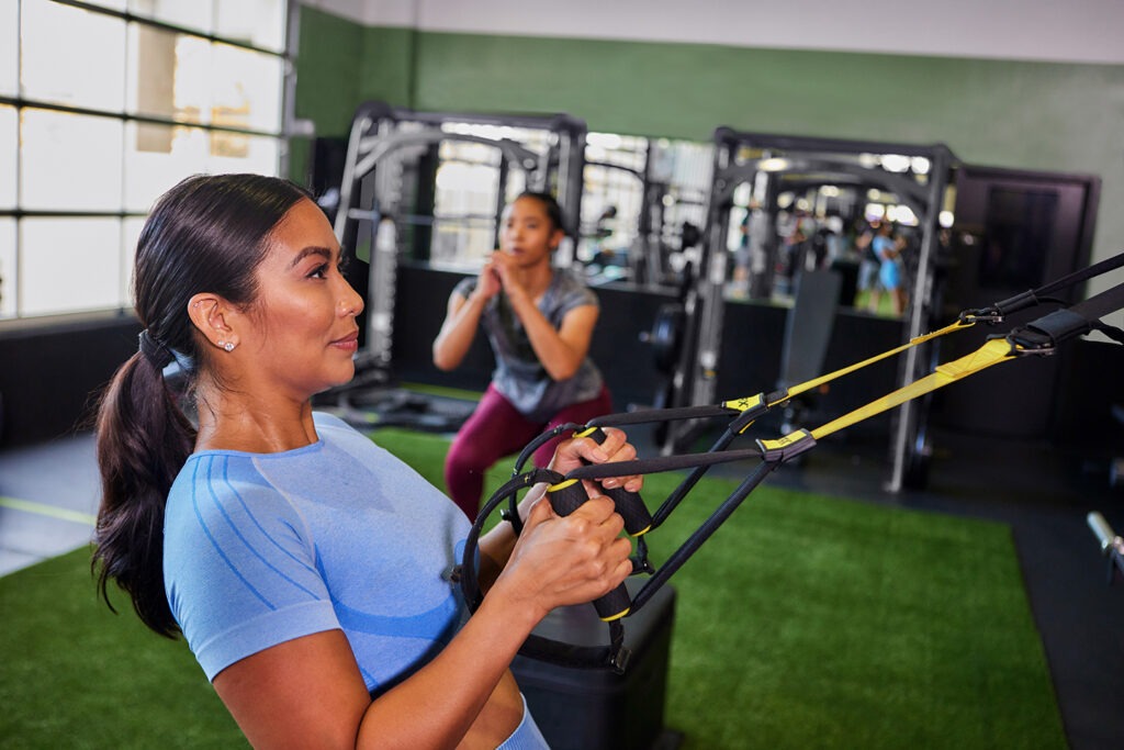 A trainer watches happy a woman training
